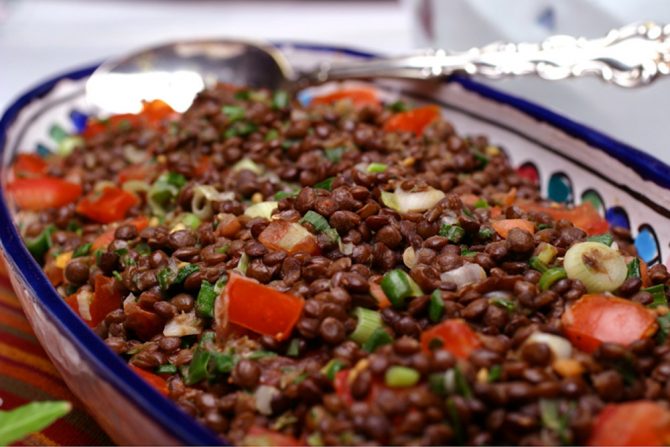 A side dish of French Green Lentils braised and tossed with scallions, tomato, and lots of fresh herbs